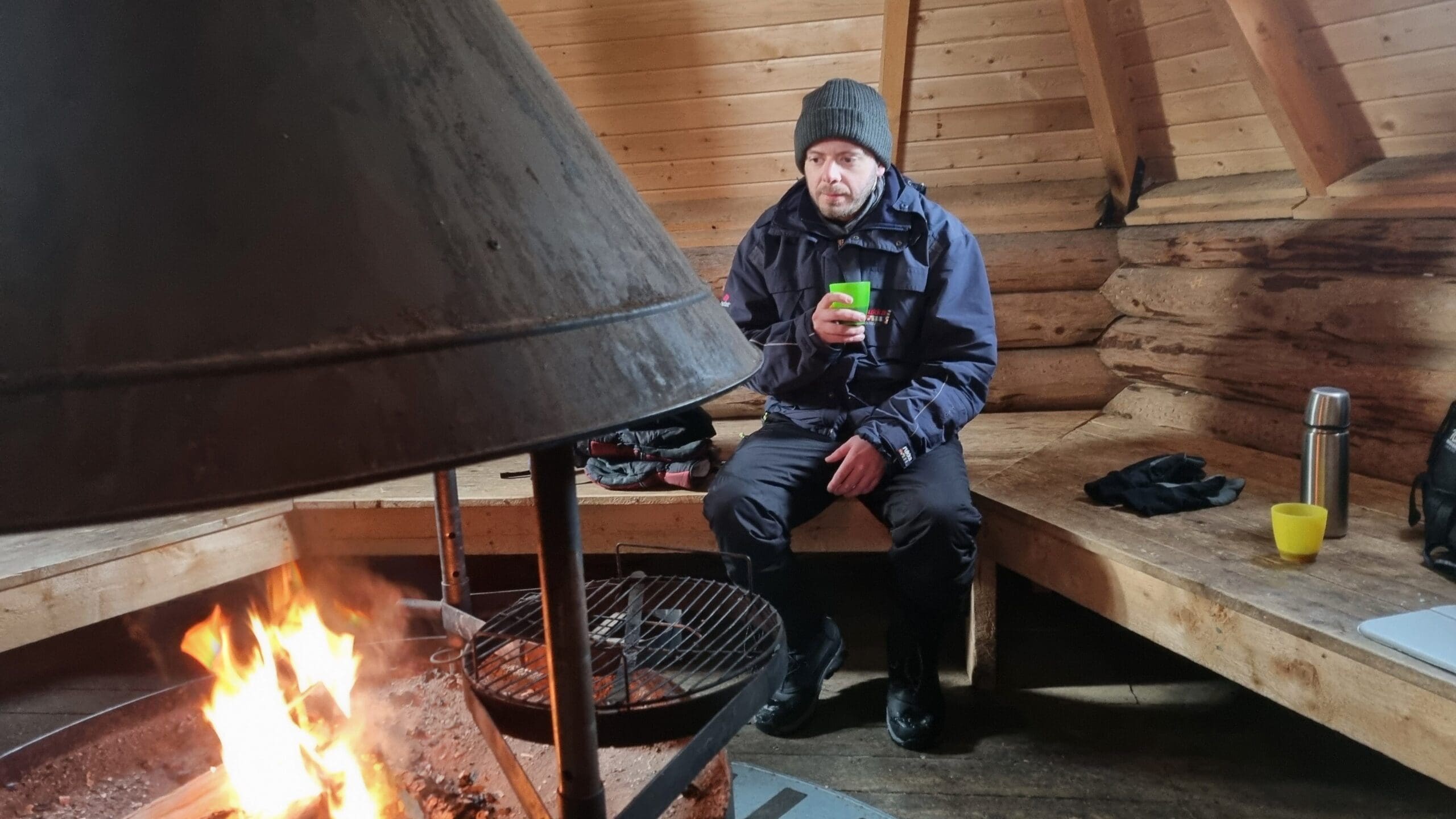 Andy warming up by a Kota fire in Lapland, March 2022